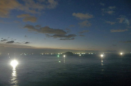 夜の海。白い光はすべて海釣りの船の光。